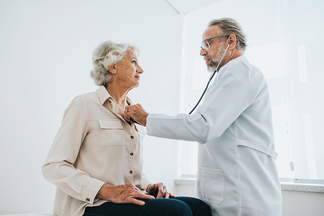 Femme âgée se faisant ausculter par un médecin.